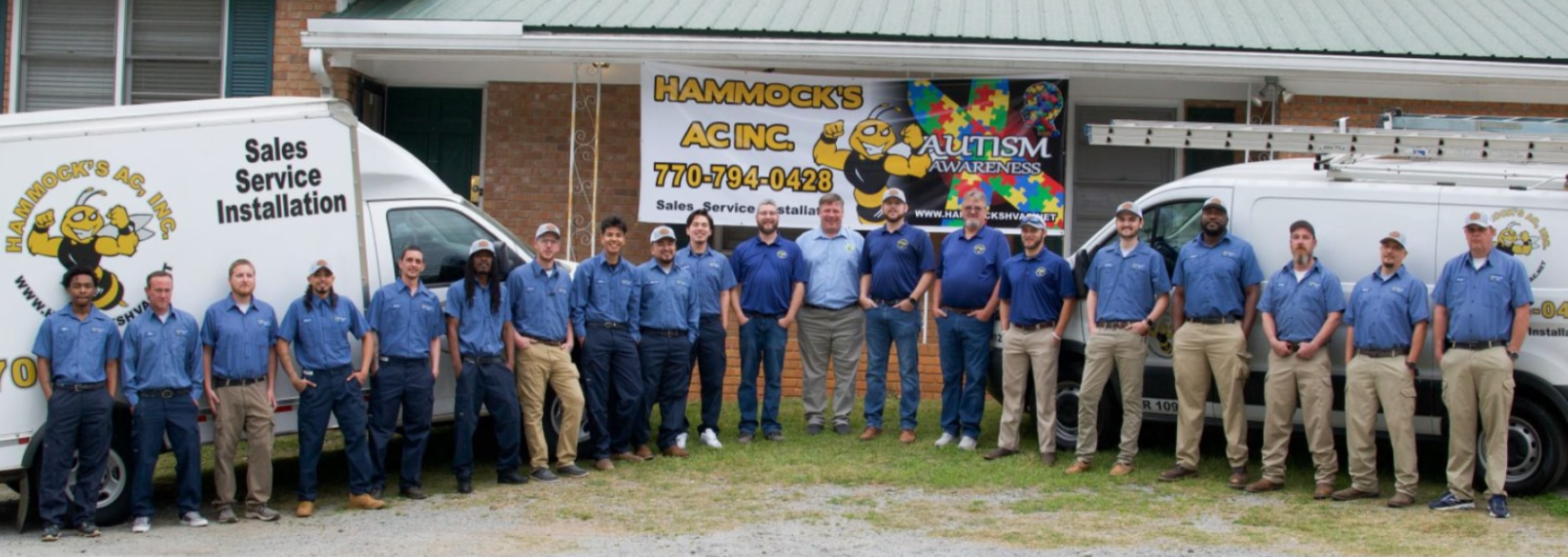 Full Hammock's AC Inc team standing in front of company vans and headquarters